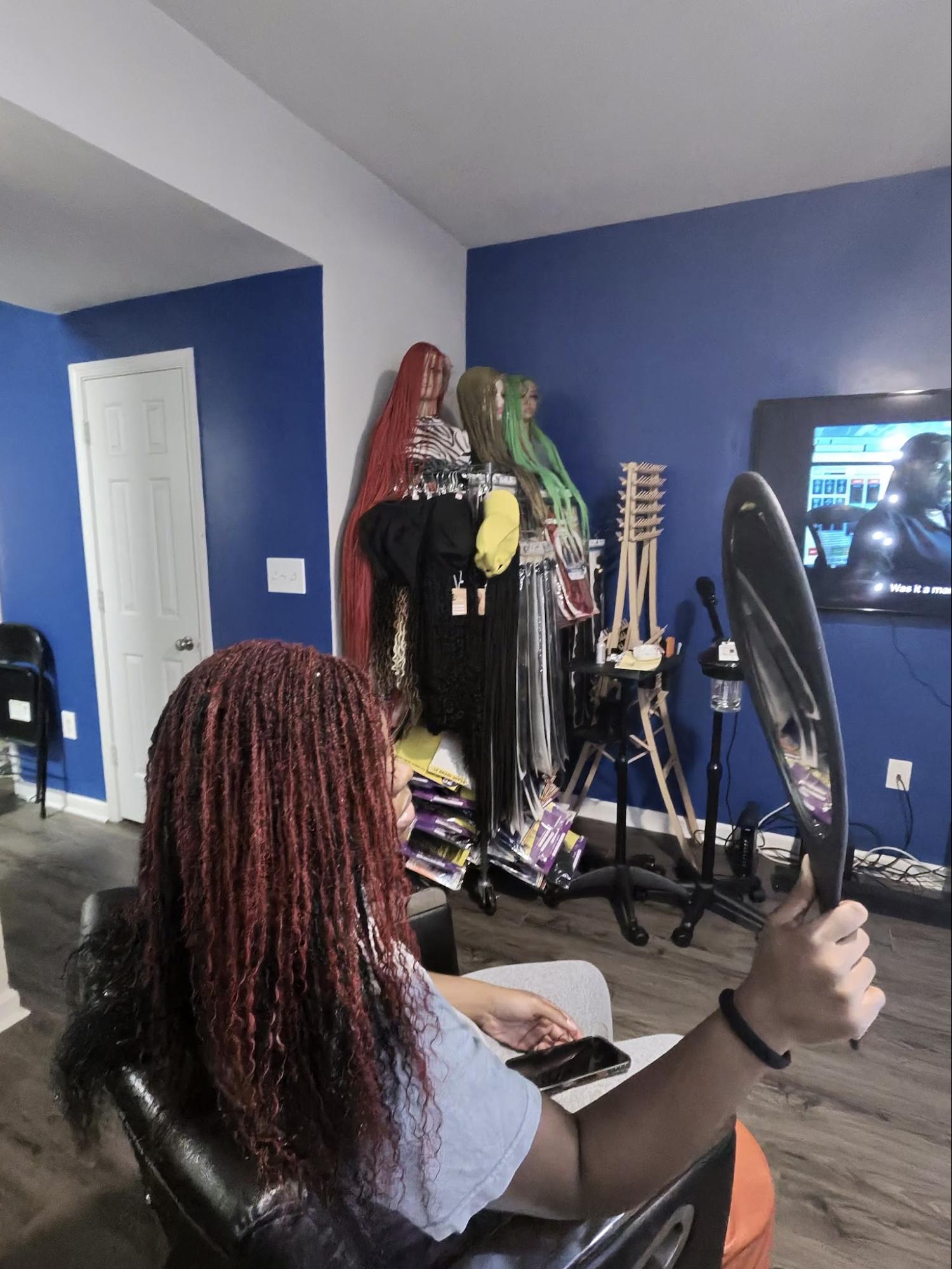Person checking reddish locs in mirror | Sisterloc Shop .